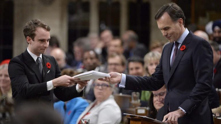<p>Finance Minister Bill Morneau gives a copy of the government&#8217;s fall economic update to a page in the House of Commons on Parliament Hill in Ottawa on Tuesday, November 1, 2016. THE CANADIAN PRESS/Adrian Wyld</p>
