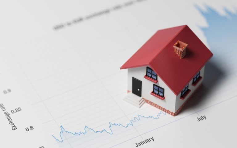 Miniature House on A Blue Financial Graph representing investing in real estate