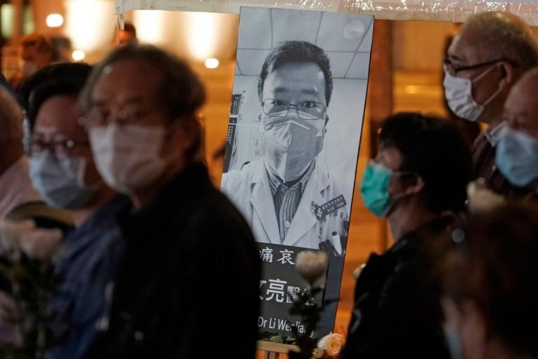 In this Feb. 7, 2020, file photo, people wearing masks attend a vigil for Chinese doctor Li Wenliang, who was reprimanded for warning about the outbreak of the new coronavirus, in Hong Kong. China has taken the highly unusual move of exonerating the doctor who was reprimanded for warning about the coronavirus outbreak and later died of the disease. An official media report said police in Wuhan had revoked its admonishment of Dr. Li that had included a threat of arrest and issued a solemn apology" to his family. (Kin Cheung/AP File/CP)
