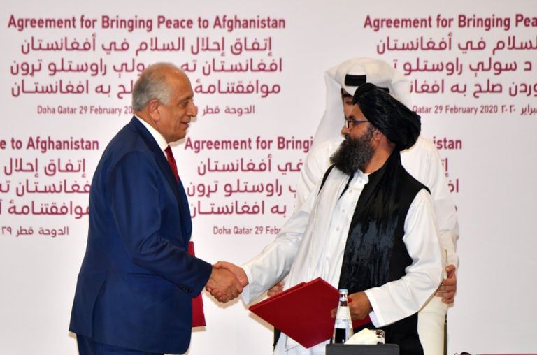 Special Representative for Afghanistan Reconciliation Zalmay Khalilzad and Taliban co-founder Mullah Abdul Ghani Baradar shake hands after signing a peace agreement in the Qatari capital Doha on Feb. 29, 2020 (GIUSEPPE CACACE/AFP via Getty Images)