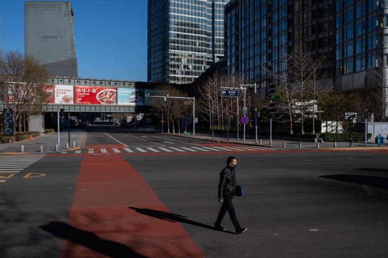 A man crosses a deserted street in the financial district in Beijing on March 3, 2020 (Nicolas Asfouri/AFP/Getty Images)