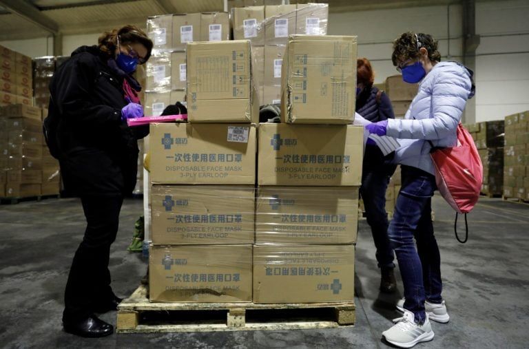 Workers sort out all the personal protective equipment (PPE) received from China at a warehouse in Valencia, Spain, on Mar. 25 2020. A total of 3,800,000 masks, 5,000 protective suits and 2,000,000 gloves arrived to Valencia region to equip hospitals and elderly homes. (Juan Carlos Cardenas/EPA/CP)