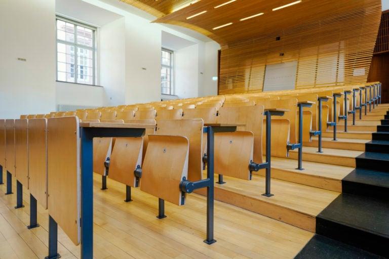 Empty desks in a lecture hall (Photo by Uwe Anspach/picture alliance via Getty Images)
