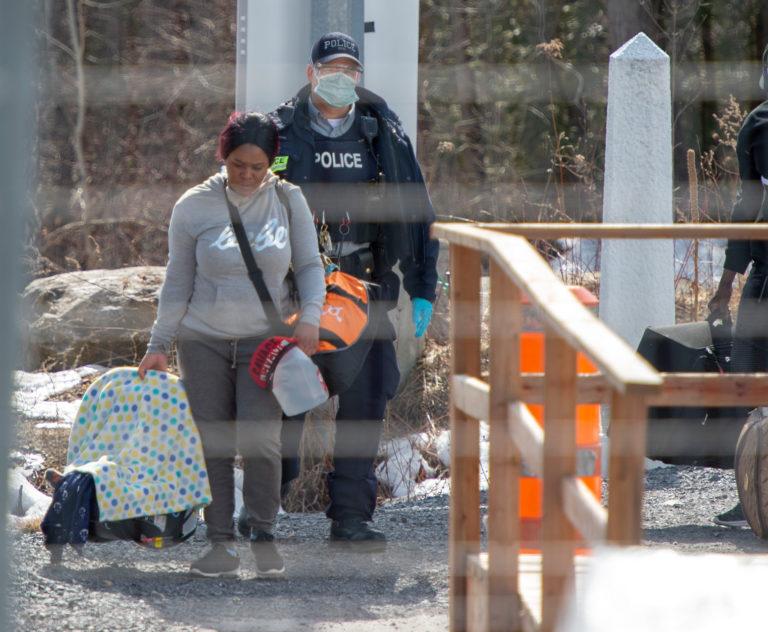 Asylum seekers cross the border from New York into Canada at Roxham Road Wednesday, March 18, 2020 in Hemmingford, Quebec. (Ryan Remiorz/CP)