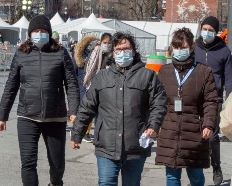 People wear masks as they leave the COVID-19 testing facility Friday, March 27, 2020 in Montreal.THE CANADIAN PRESS/Ryan Remiorz