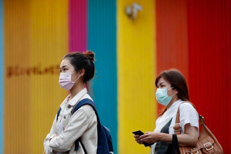 Taiwanese wearing masks as precautionary measures against coronavirus walk past at a street in Taipei, Taiwan, 26 Mar. 2020. (Ritchie B. Tongo/EPA/CP)