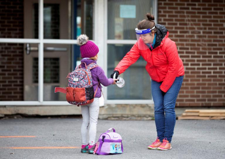 A student Saint-Jean-sur-Richelieu, Que. has her hands sanitized, as schools outside the greater Montreal region begin to reopen their doors. (Christinne Muschi/Reuters)