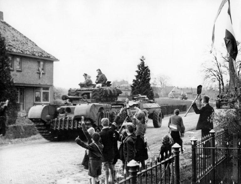 Picture released on April 12, 1945 of Dutch civilians waving to the Canadian soldiers driving through a village of Netherlands, during the Second World War. (AFP/Getty Images)