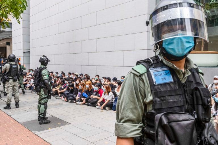 A large group of detainees are seen sitting on the ground in Hong Kong, China, 27 May 2020. Beijing plans to impose a national security law on the city banning sedition, secession and subversion through a method that could bypass Hong Kong's legislature. (Miguel Candela/EPA/CP)