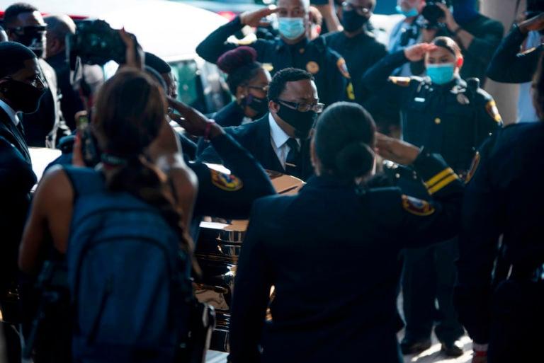 Police officers salute as pallbearers bring the coffin into the church for the funeral for George Floyd (Mark Felix/AFP/Getty Images)