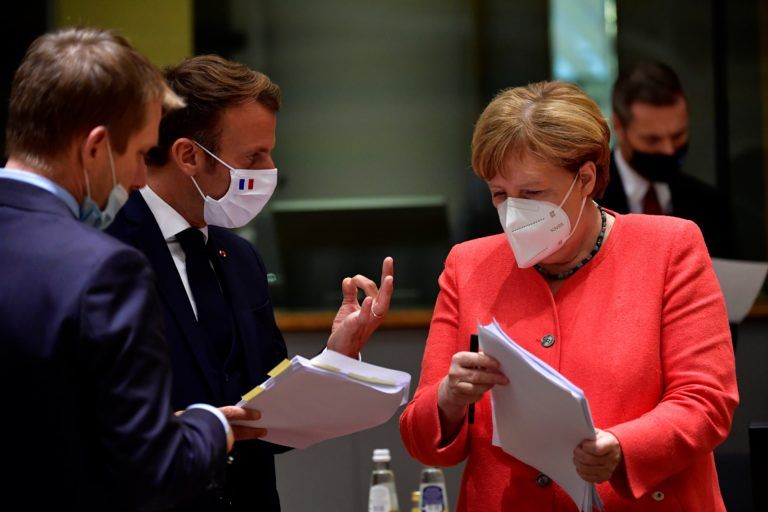 German Chancellor Angela Merkel looks on next to French President Emmanuel Macron during an EU summit in Brussels on July 20, 2020 (JOHN THYS/POOL/AFP via Getty Images)