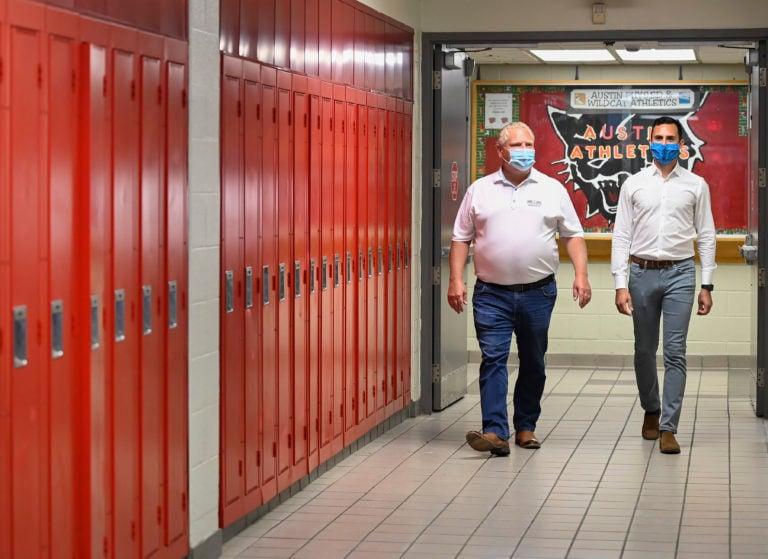 Ontario Premier Doug Ford, left, and Education Minister Stephen Lecce walk the hallway before making an announcement regarding the governments plan for a safe reopening of schools in the fall due to the COVID-19 pandemic at Father Leo J Austin Catholic Secondary School in Whitby, Ont., on Thursday, July 30, 2020. THE CANADIAN PRESS/Nathan Denette