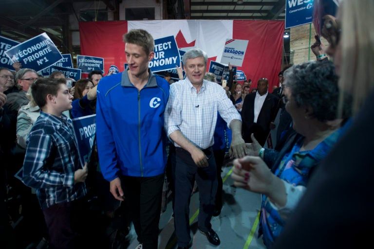 Conservative Leader Stephen Harper greets supporters as son, Ben, centre-left, walks past during a campaign stop in Fredericton, N.B., on Friday, Oct. 16, 2015. (Jonathan Hayward/CP)