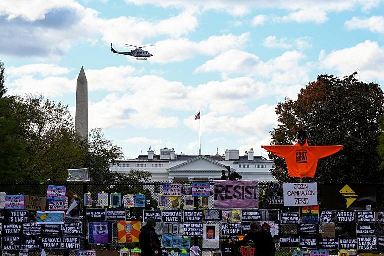 Helicopter passes over the White House, seen behind a fence and protest posters, the day before the U.S. presidential election in Washington, D.C., U.S., November 2, 2020. (Erin Scott/Reuters)