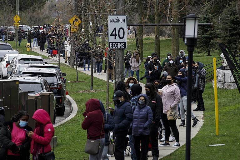 Residents of Toronto's Jane and Finch neighbourhood, in the M3N postal code, line up at a pop-up COVID-19 vaccine clinic on Saturday, April 17, 2021. THE CANADIAN PRESS/Cole Burston