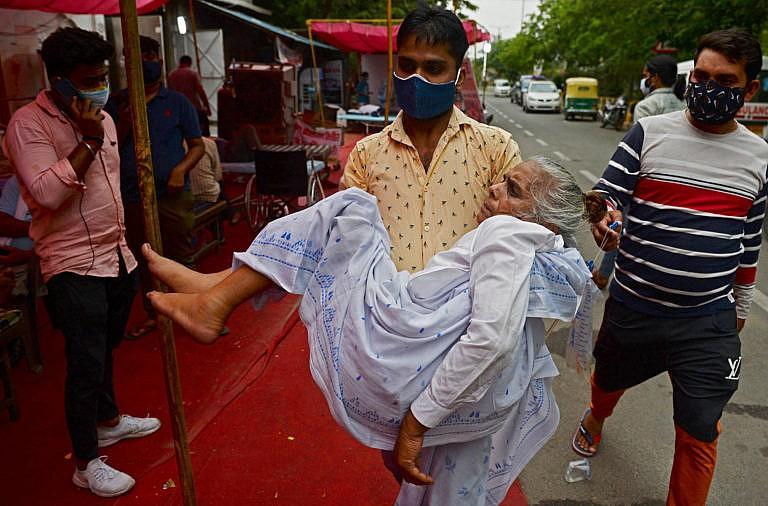 A family member carries a patient who is having difficulty in breathing, to a free oxygen support centre being run by a Gurudwara, a place of worship for Sikhs amid Covid-19 coronavirus pandemic on the outskirts of New Delhi on May 10, 2021. (Arun Sankar/AFP/Getty Images)