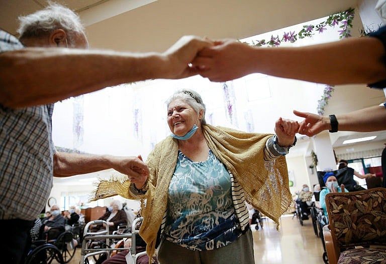 Residents and staff dance during an Easter concert for vaccinated residents at the Ararat Nursing Facility in Los Angeles, CA (Mario Tama/Getty Images)