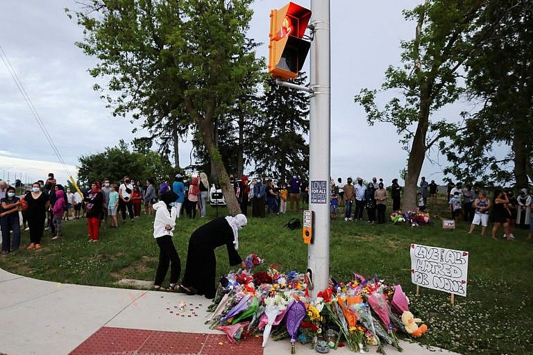 People are seen at a makeshift memorial at the fatal crime scene where a man driving a pickup truck jumped the curb and ran over a Muslim family in what police say was a deliberately targeted anti-Islamic hate crime, in London, Ontario, Canada June 7, 2021. (Carlos Osorio/Reuters)