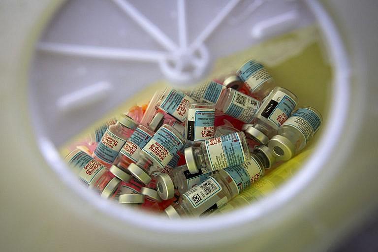 Empty vials of Moderna COVID-19 in a sharp container before a vaccine clinic in Kingston, Ontario on Friday July 2, 2021. THE CANADIAN PRESS IMAGES/Lars Hagberg