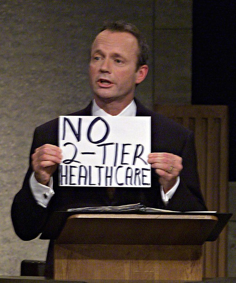 Canadian Alliance Leader Stockwell Day holds up a sign to make a point on national health care during the English leaders' debate on Nov. 9, 2000 (Tom Hanson/CP)