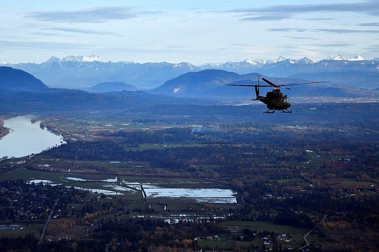 An RCAF helicopter surveys the scene after rainstorms lashed British Columbia, triggering landslides and floods, shutting highways, in Abbottsford, B.C., Nov. 21, 2021. (Jennifer Gauthier, pool/CP)