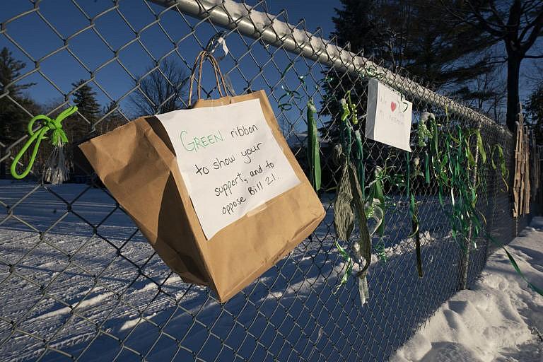 Signs and ribbons hang on a fence outside an elementary school protesting Quebec Bill 21 on Dec. 9, 2021 in Chelsea, Que (Adrian Wyld/CP)