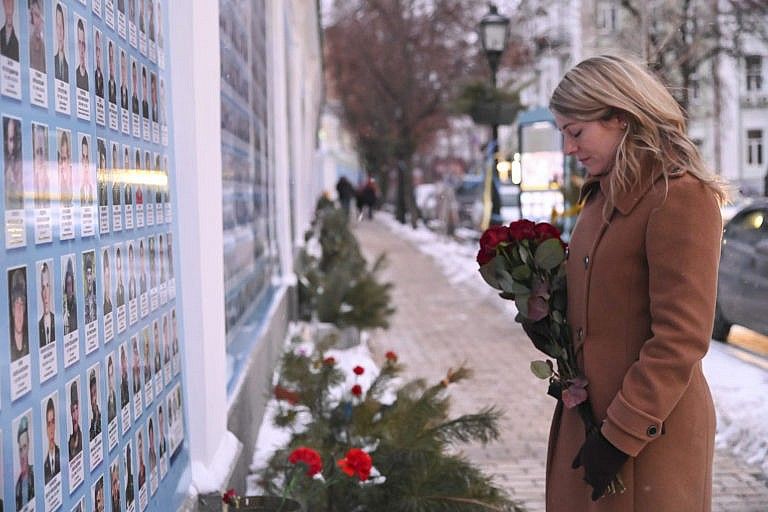 Canada's Minister of Foreign Affairs Melanie Joly lays flowers at the Memorial Wall of Fallen Defenders of Ukraine in Russian-Ukrainian War in Kyiv, Ukraine, Jan. 18, 2022. (Ukrainian Foreign Ministry Press Office via AP)