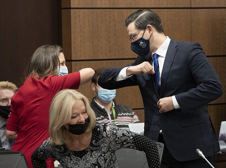 Deputy Prime Minister Chrystia Freeland bumps elbows with Poilievre before appearing at the House of Commons Finance committee, on Dec. 9, 2021 in Ottawa (Adrian Wyld/CP)