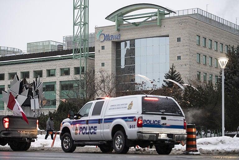 A police vehicle sits outside Ottawa City Hall after Ottawa Mayor Jim Watson declared a state of emergency for Ottawa, Feb. 6, 2022. (Justin Tang/The Canadian Press)