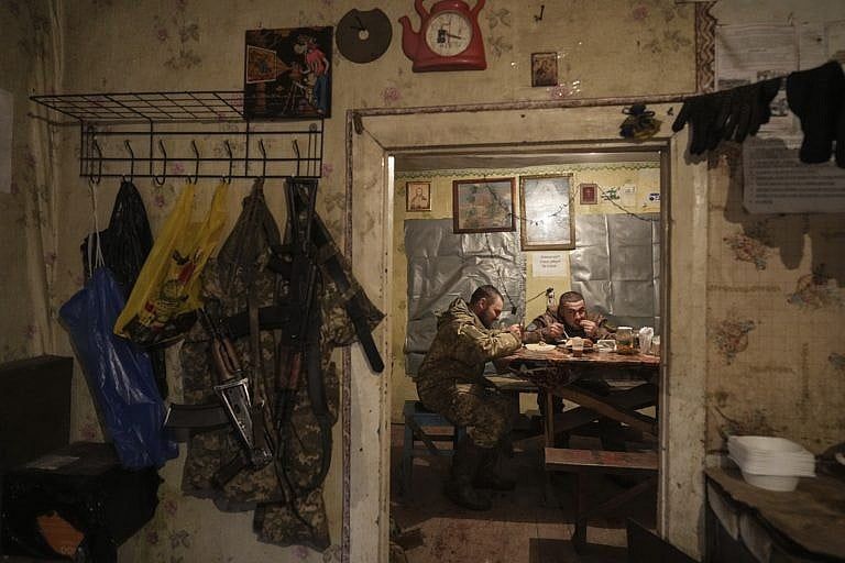 Ukrainian servicemen eating dinner last week after their duty at the frontline near Svitlodarsk, in eastern Ukraine. (Evgeniy Maloletka/AP)