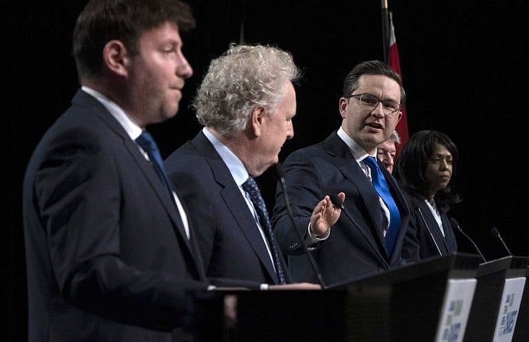 Conservative leadership candidate Pierre Poilievre gestures towards Jean Charest as Roman Baber, left, Scott Aitchison and Leslyn Lewis, right, look on during a debate in Ottawa, May 5, 2022. (Adrian Wyld/The Canadian Press)